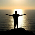 Силуэт человека на фоне восходящего солнца символизирующий духовное пробуждение